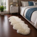 Real sheepskin rug in tan placed beside a bed on dark hardwood floor in a bedroom setting