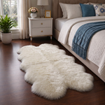 Real sheepskin rug in tan placed beside a bed on dark hardwood floor in a bedroom setting