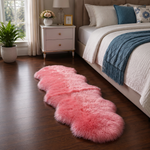 Real sheepskin rug in tan placed beside a bed on dark hardwood floor in a bedroom setting