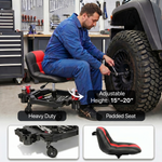 Mechanic seated on a red rolling garage stool adjusting a truck tire with a wrench