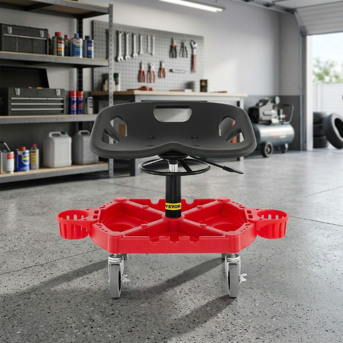 Red and black padded rolling mechanic stool with a divided tool tray and five casters in a garage