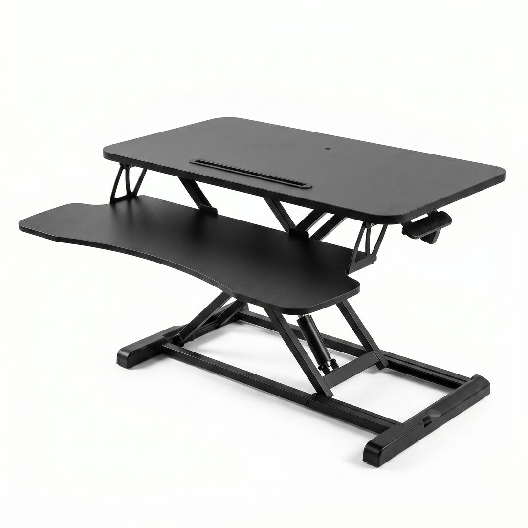 Black standing desk converter shown raised to standing height with keyboard tray