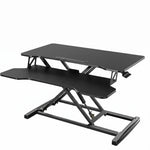 Black standing desk converter shown raised to standing height with keyboard tray