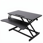 Black standing desk converter shown raised to standing height with keyboard tray