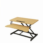 Black standing desk converter shown raised to standing height with keyboard tray