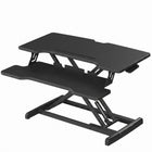 Black standing desk converter shown raised to standing height with keyboard tray