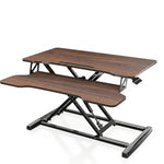 Black standing desk converter shown raised to standing height with keyboard tray extended