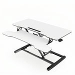Black standing desk converter shown raised to standing height with keyboard tray