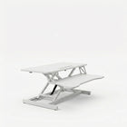 Black standing desk converter shown raised to standing height with keyboard tray