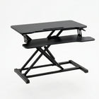 Black standing desk converter shown raised to standing height with keyboard tray