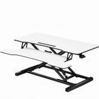 Black standing desk converter shown raised to standing height with keyboard tray