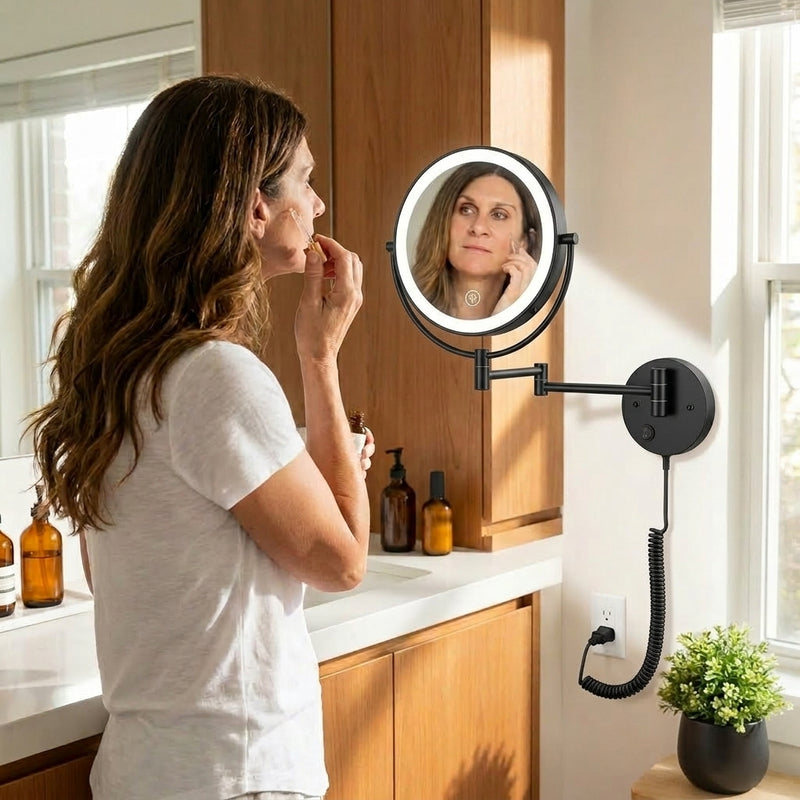 Woman applying makeup using a wall-mounted LED magnifying mirror at a bathroom vanity