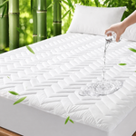 Quilted waterproof mattress protector on a bed in a bright bedroom