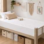 Quilted waterproof mattress protector on a bed in a bright bedroom