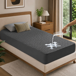 Quilted waterproof mattress protector on a bed in a bright bedroom