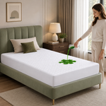 Quilted waterproof mattress protector on a bed in a bright bedroom