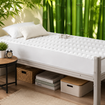 Quilted waterproof mattress protector on a bed in a bright bedroom